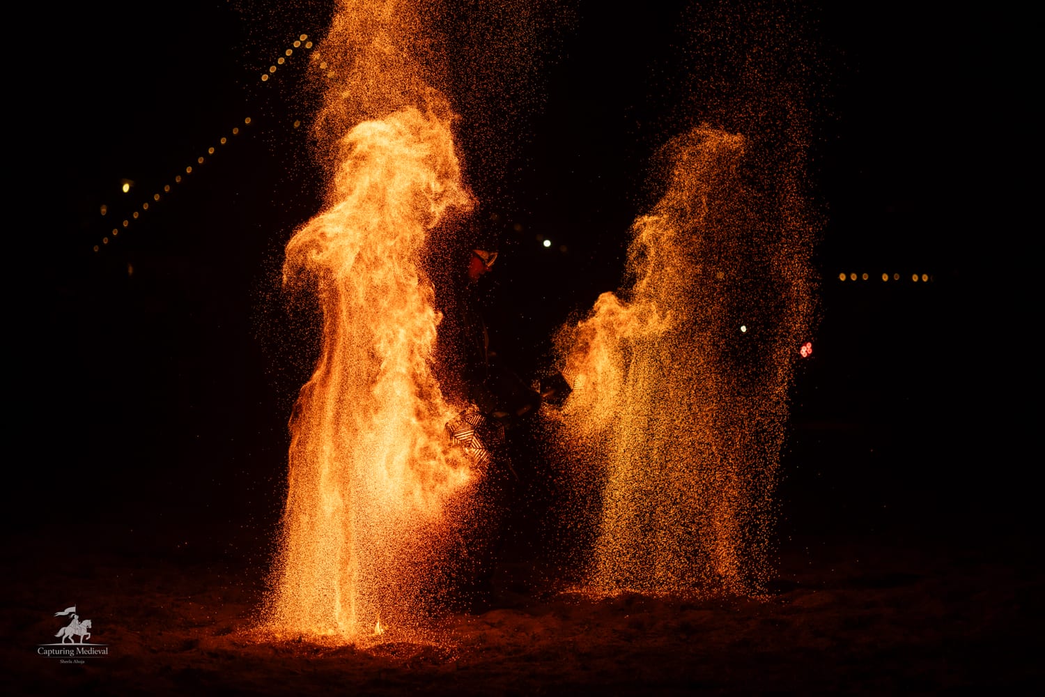 Zwei haushohe Funkensäulen aus glühender Kohle als Finale einer Feuershow bei Nacht