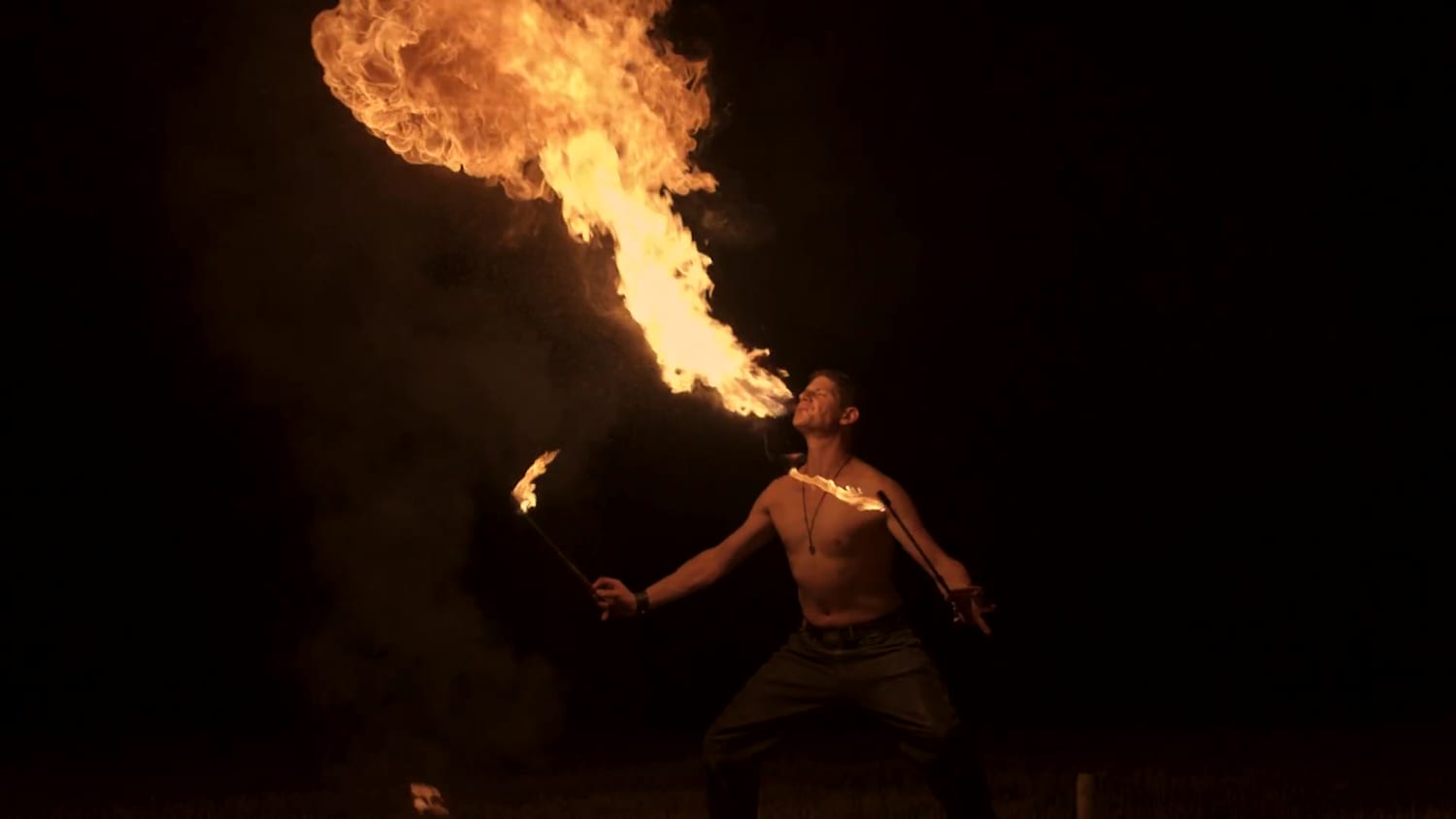 Der Feuermagier speit eine hohe Flamme in den Nachthimmel – Standbild aus dem Showreel